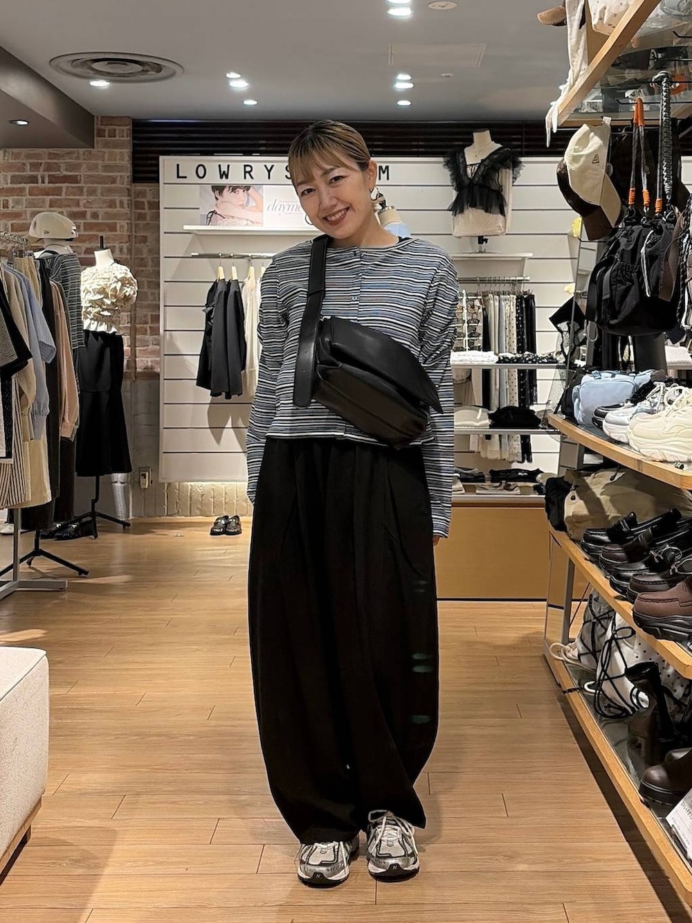 ブラック系のショルダーバッグ、ブルー系のカーディガン/ボレロ、ブラック系のその他パンツを着用したレディースの秋コーディネートの2枚目の写真
