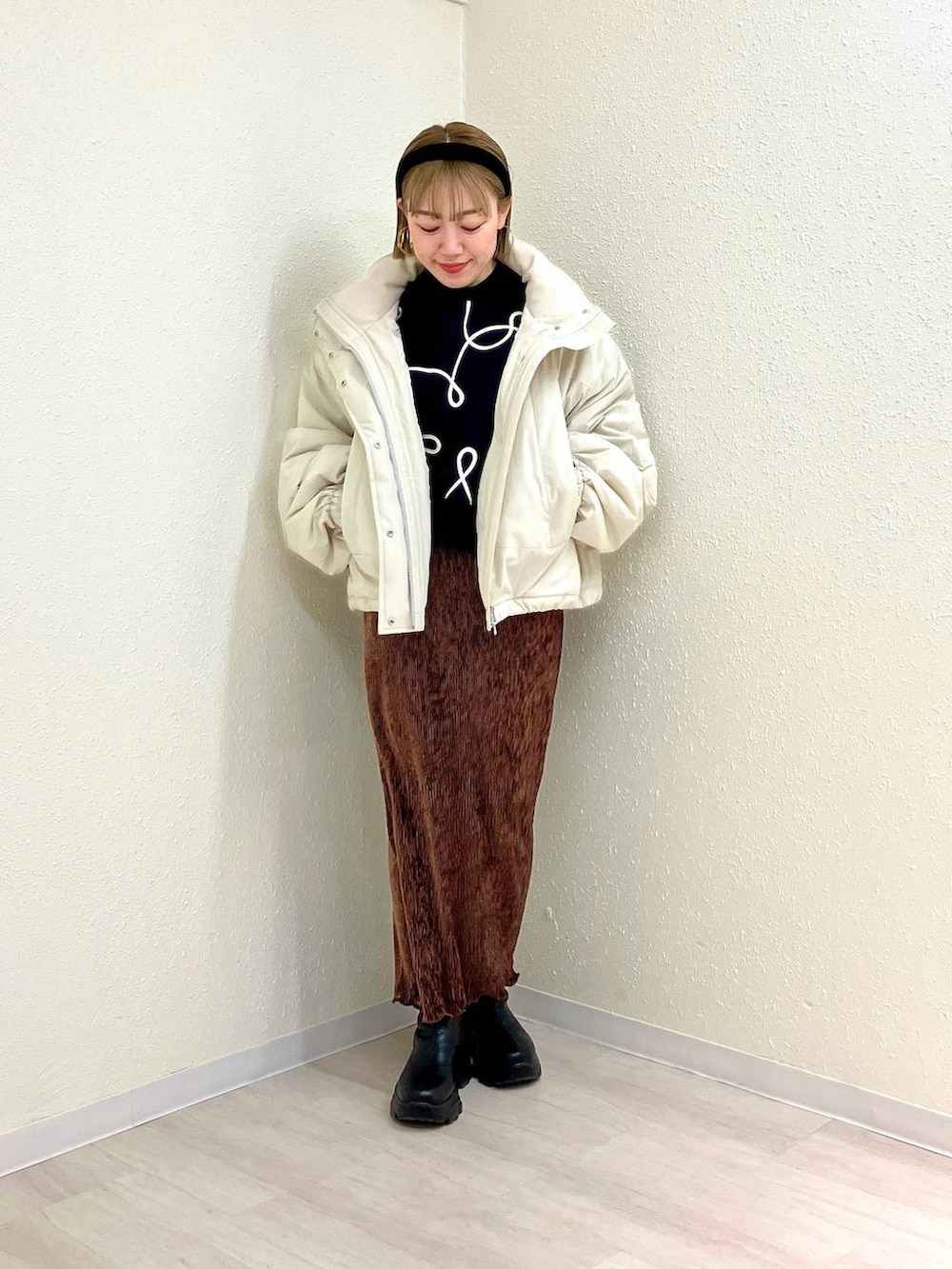 ホワイト系のその他アウター、ブラック系のブーツ、ブラウン系のスカートを着用したレディースの冬コーディネートの6枚目の写真