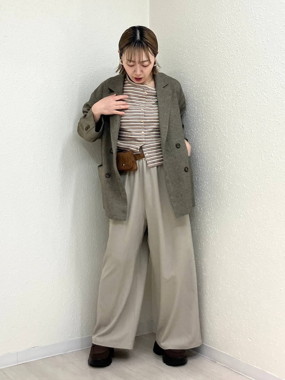 ベージュ系のその他パンツ、ブラウン系のテーラードジャケット、ブラウン系のローファーを着用したレディースの春コーディネートの6枚目の写真