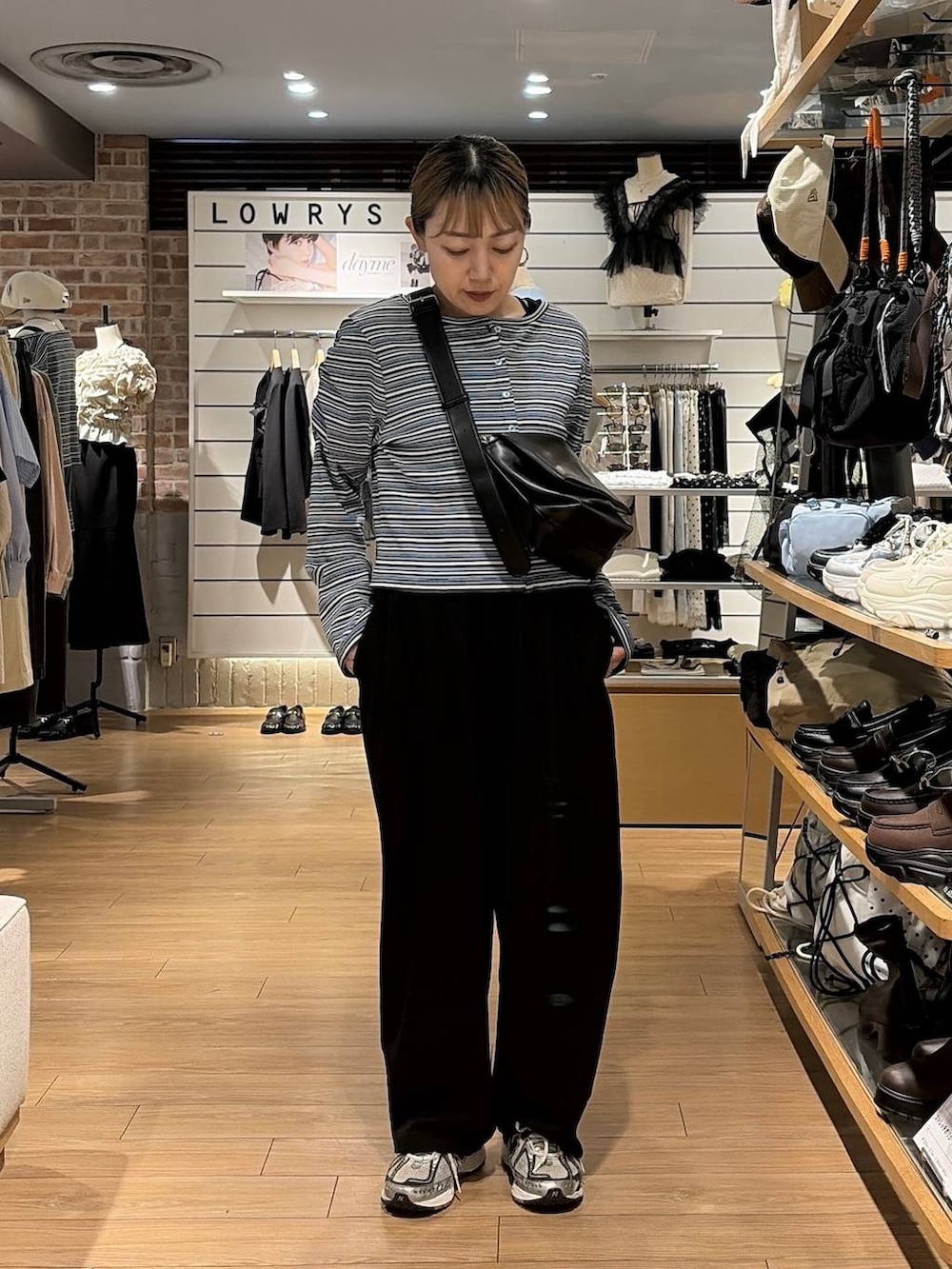 ブラック系のショルダーバッグ、ブルー系のカーディガン/ボレロ、ブラック系のその他パンツを着用したレディースの秋コーディネートの4枚目の写真