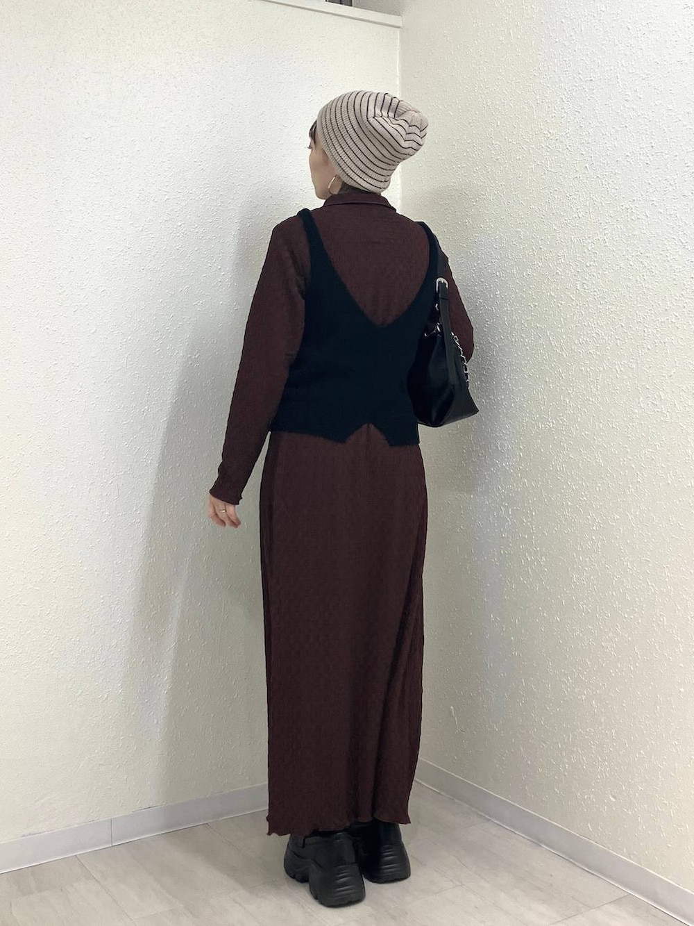 ブラック系のショルダーバッグ、ブラック系のローファー、ブラウン系のワンピースを着用したレディースの冬コーディネートの6枚目の写真