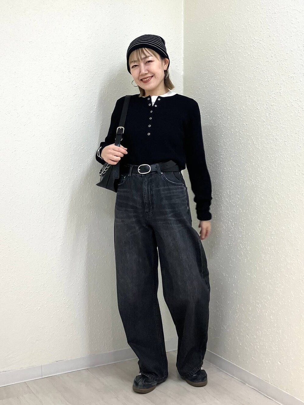 ブラック系のニット/セーター、ブラック系のデニムパンツ、ブラック系のショルダーバッグを着用したレディースの冬コーディネートの7枚目の写真