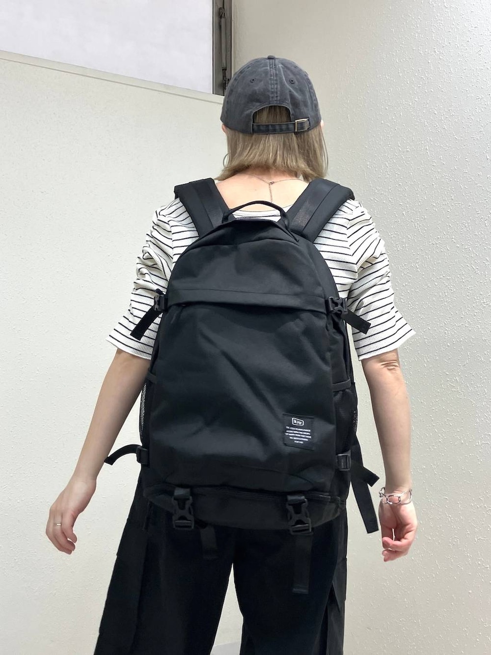ブラック系のサンダル、ブラック系のカーゴパンツ、ホワイト系のTシャツ/カットソーを着用したレディースの春コーディネートの3枚目の写真