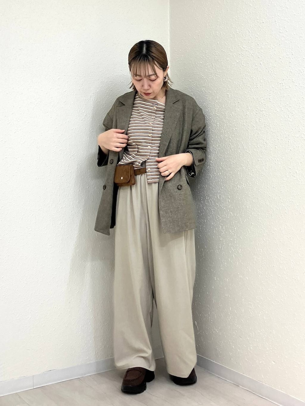 ベージュ系のその他パンツ、ブラウン系のテーラードジャケット、ブラウン系のローファーを着用したレディースの春コーディネートの2枚目の写真