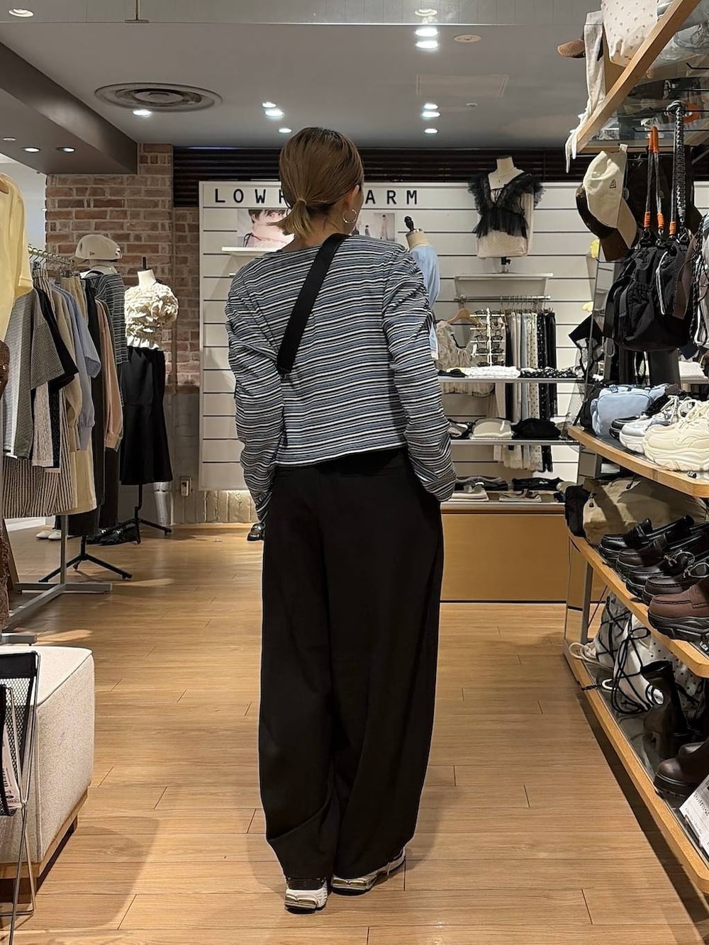 ブラック系のショルダーバッグ、ブルー系のカーディガン/ボレロ、ブラック系のその他パンツを着用したレディースの秋コーディネートの7枚目の写真