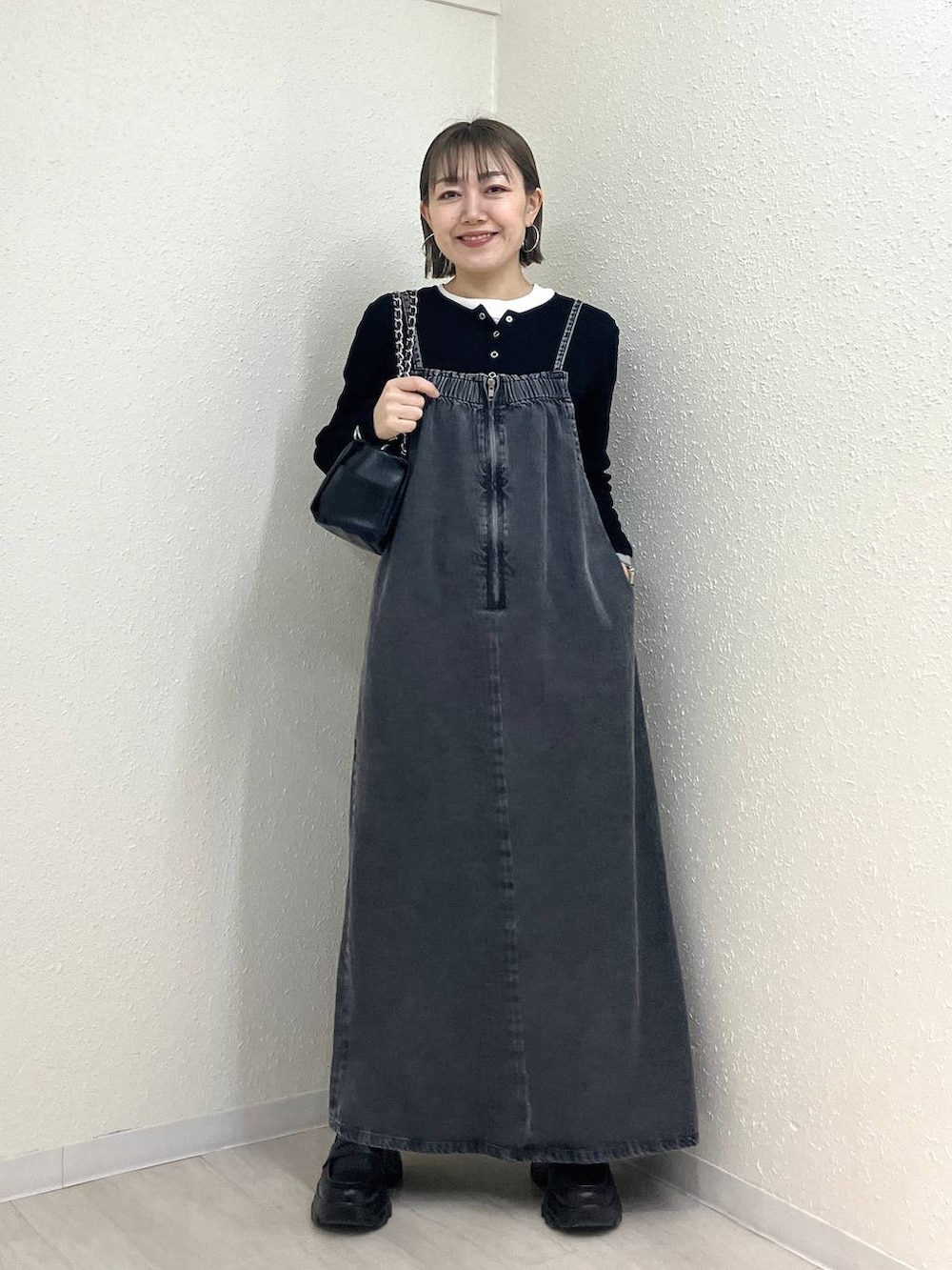 ブラック系のニット/セーター、ブラック系のショルダーバッグ、ブラック系のローファーを着用したレディースの冬コーディネートの2枚目の写真