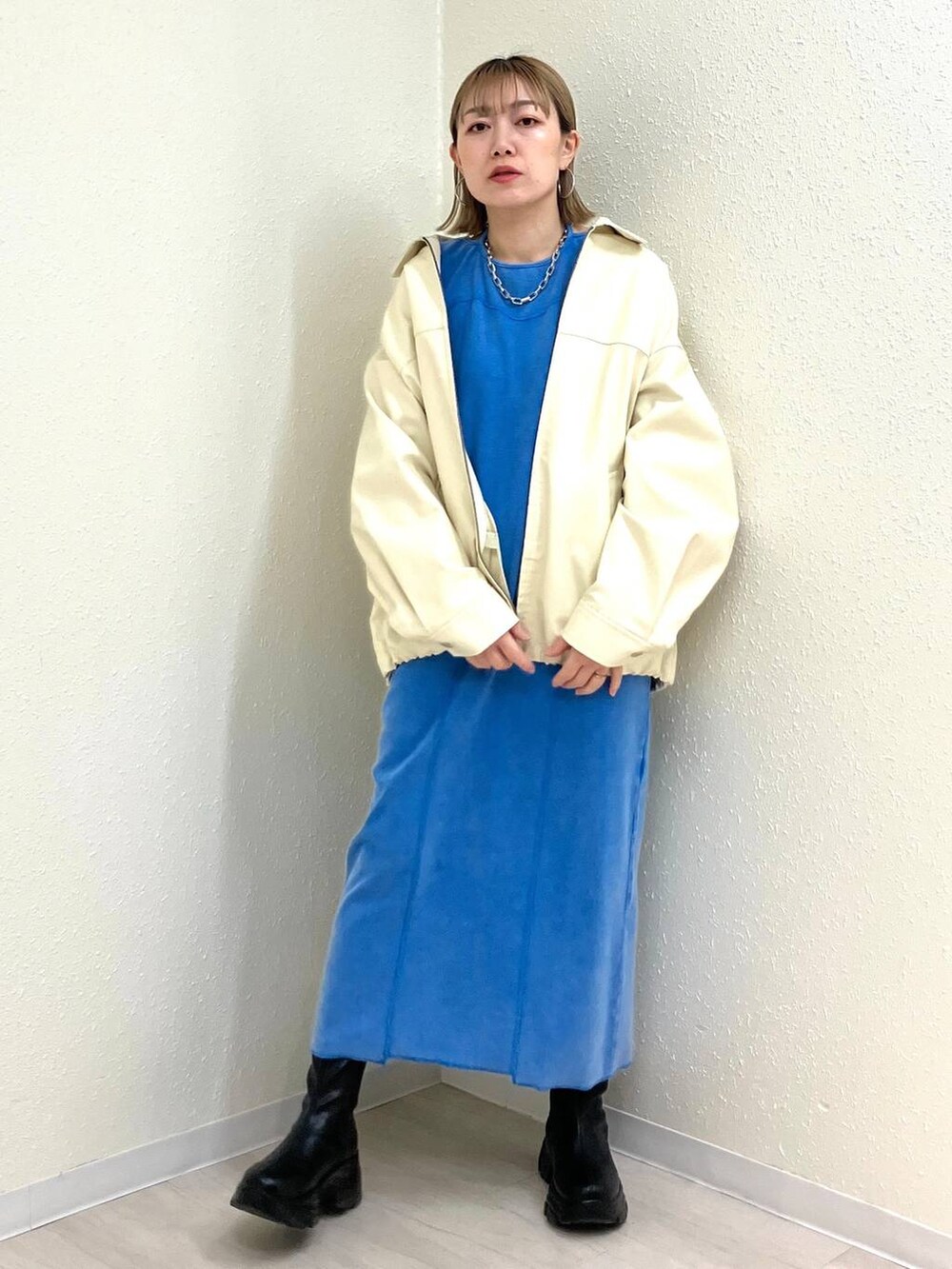 ブラック系のブーツ、ホワイト系のブルゾン、ブルー系のワンピースを着用したレディースの冬コーディネートの5枚目の写真