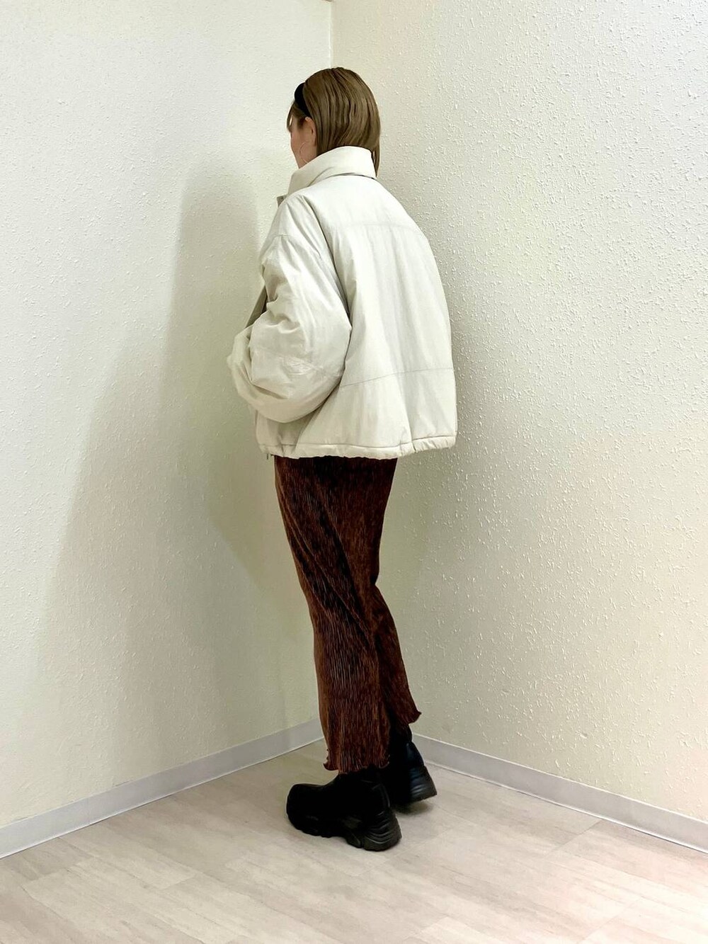 ホワイト系のその他アウター、ブラック系のブーツ、ブラウン系のスカートを着用したレディースの冬コーディネートの2枚目の写真