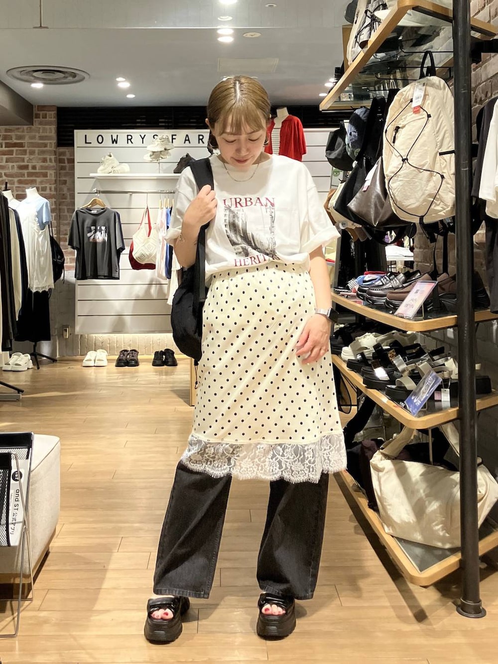 ブラック系のデニムパンツ、ブラック系のバックパック/リュック、ホワイト系のスカートを着用したレディースの夏コーディネートの7枚目の写真