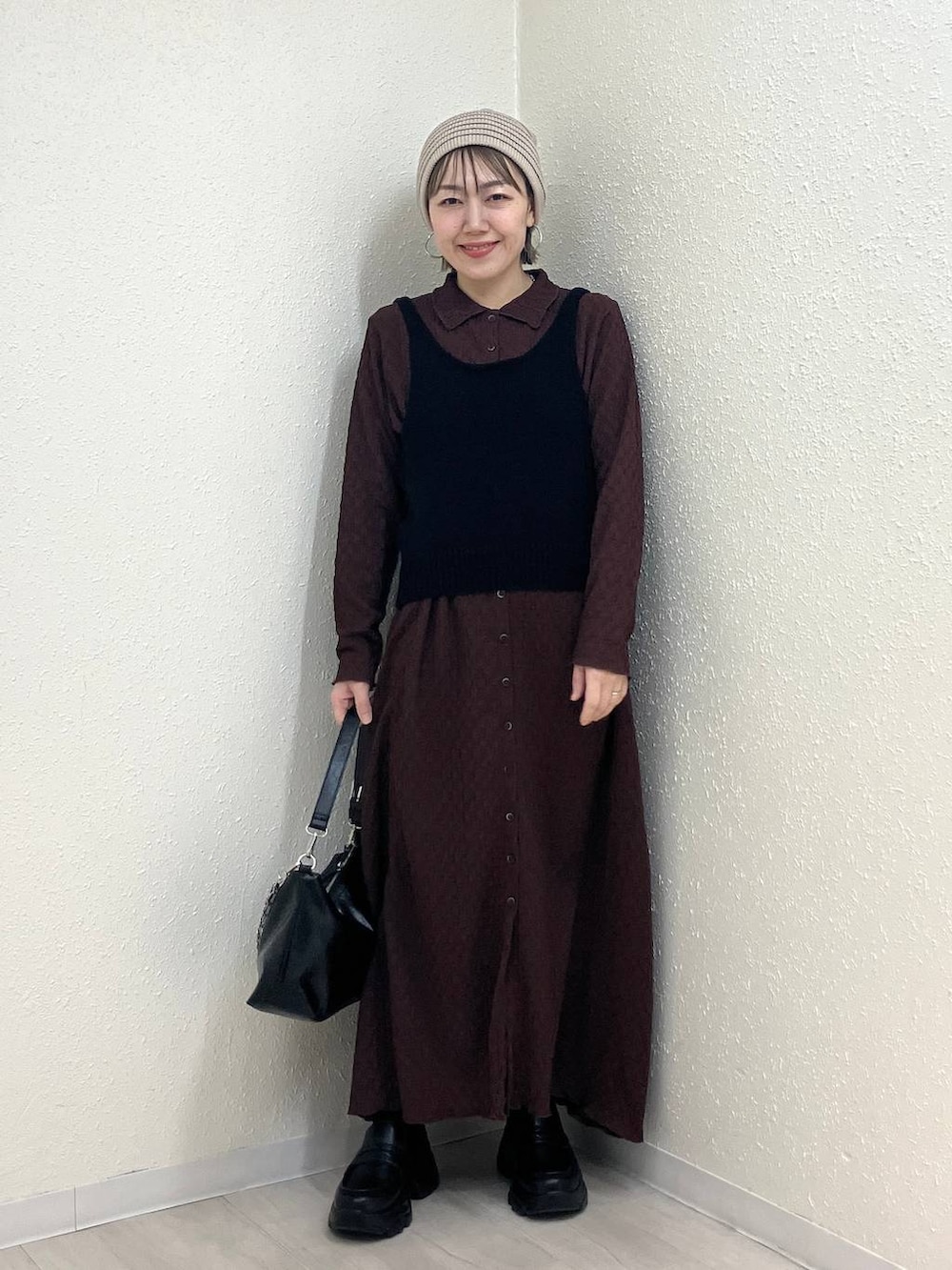 ブラック系のショルダーバッグ、ブラック系のローファー、ブラウン系のワンピースを着用したレディースの冬コーディネートの2枚目の写真