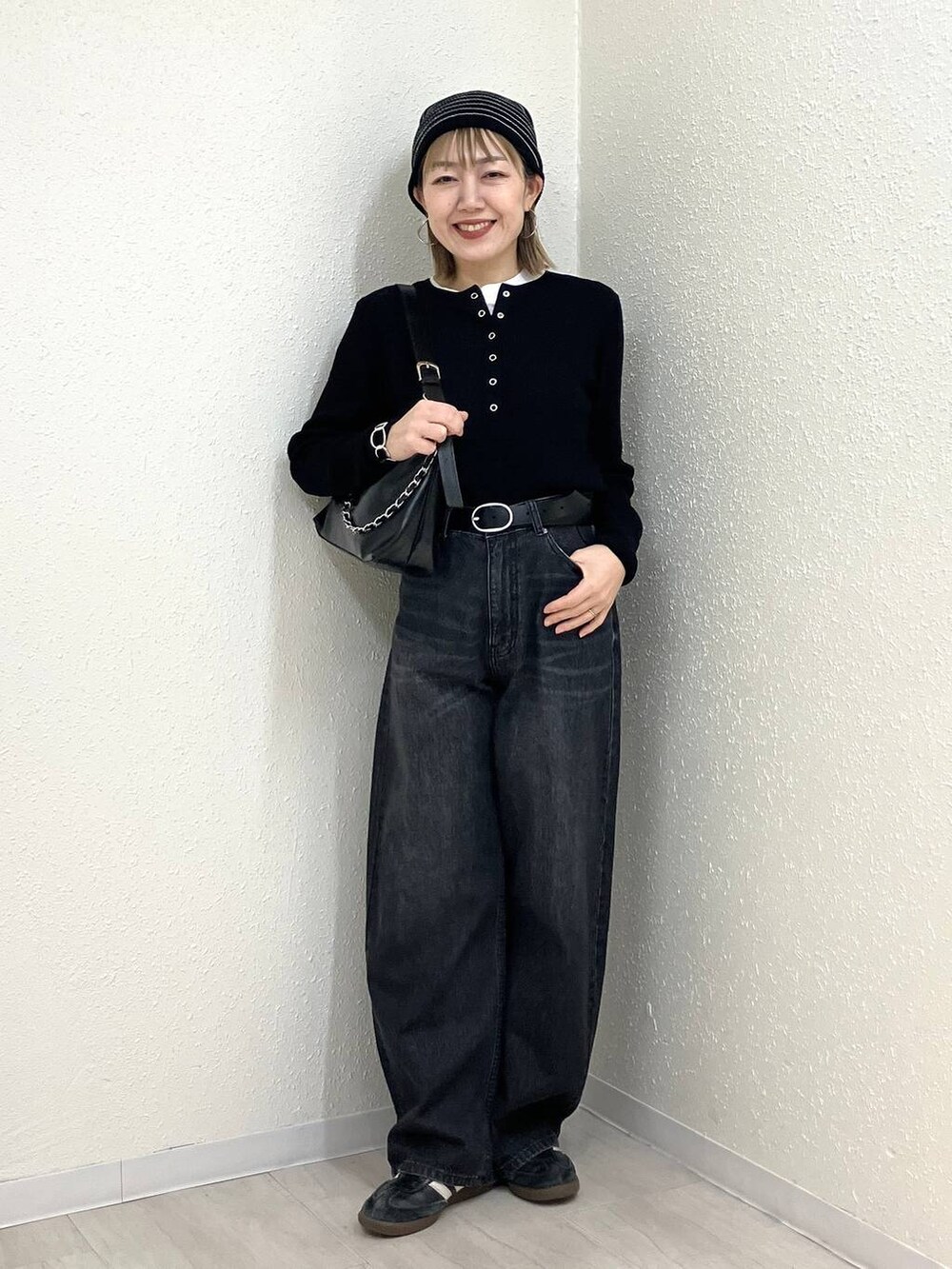 ブラック系のニット/セーター、ブラック系のデニムパンツ、ブラック系のショルダーバッグを着用したレディースの冬コーディネートの9枚目の写真