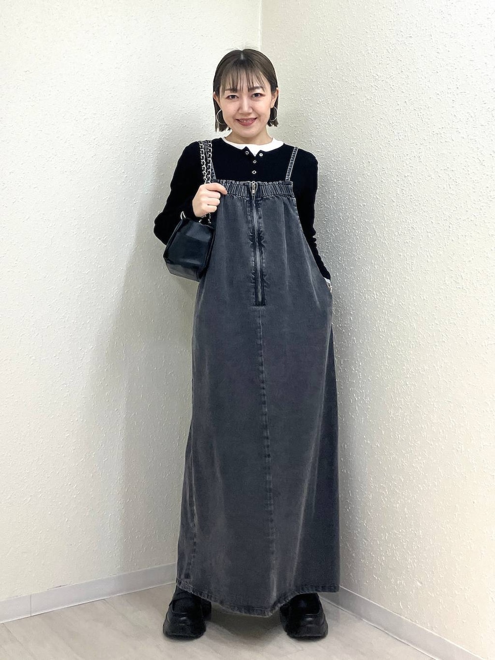 ブラック系のニット/セーター、ブラック系のショルダーバッグ、ブラック系のローファーを着用したレディースの冬コーディネートの7枚目の写真