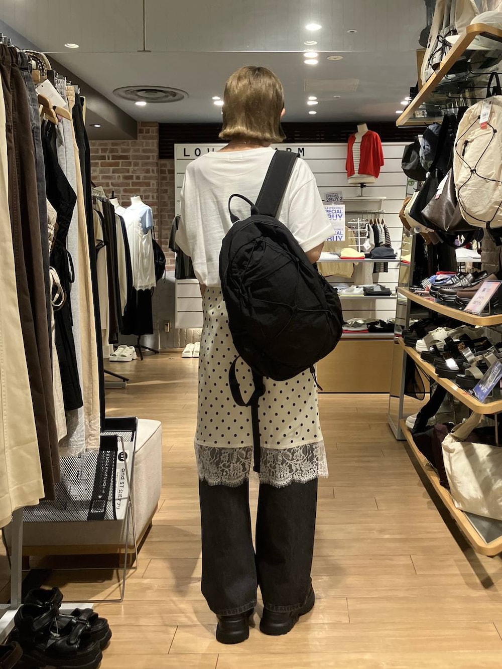 ブラック系のデニムパンツ、ブラック系のバックパック/リュック、ホワイト系のスカートを着用したレディースの夏コーディネートの3枚目の写真