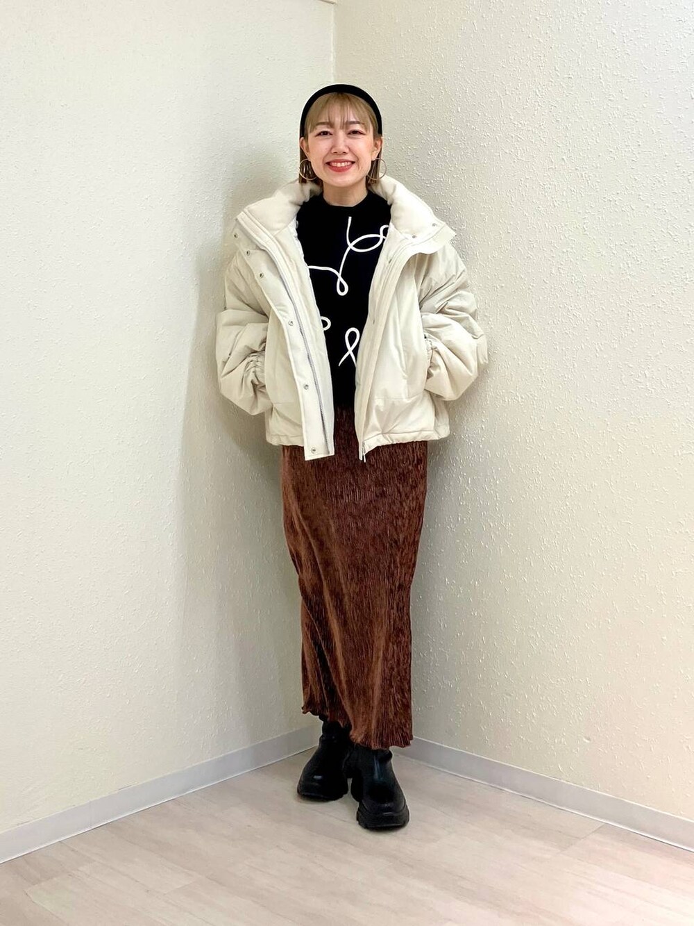 ホワイト系のその他アウター、ブラック系のブーツ、ブラウン系のスカートを着用したレディースの冬コーディネートの5枚目の写真