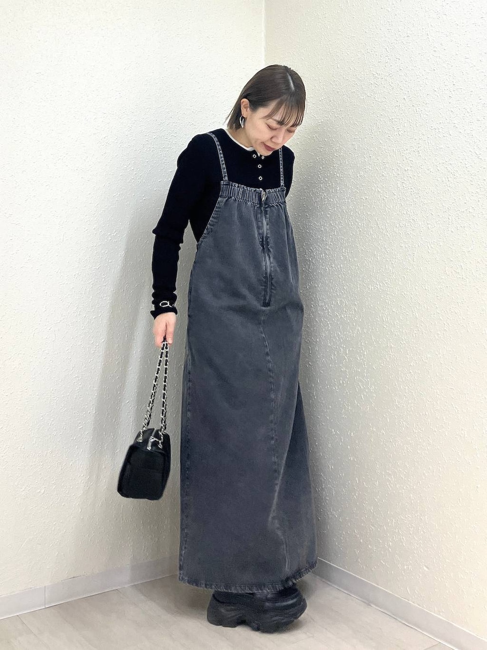 ブラック系のニット/セーター、ブラック系のショルダーバッグ、ブラック系のローファーを着用したレディースの冬コーディネートの4枚目の写真