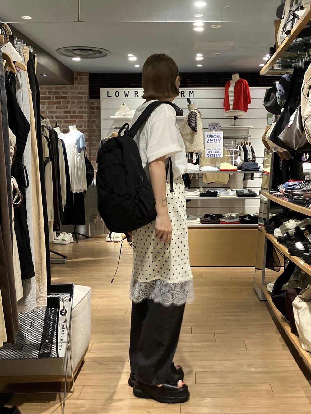 ブラック系のデニムパンツ、ブラック系のバックパック/リュック、ホワイト系のスカートを着用したレディースの夏コーディネートの6枚目の写真