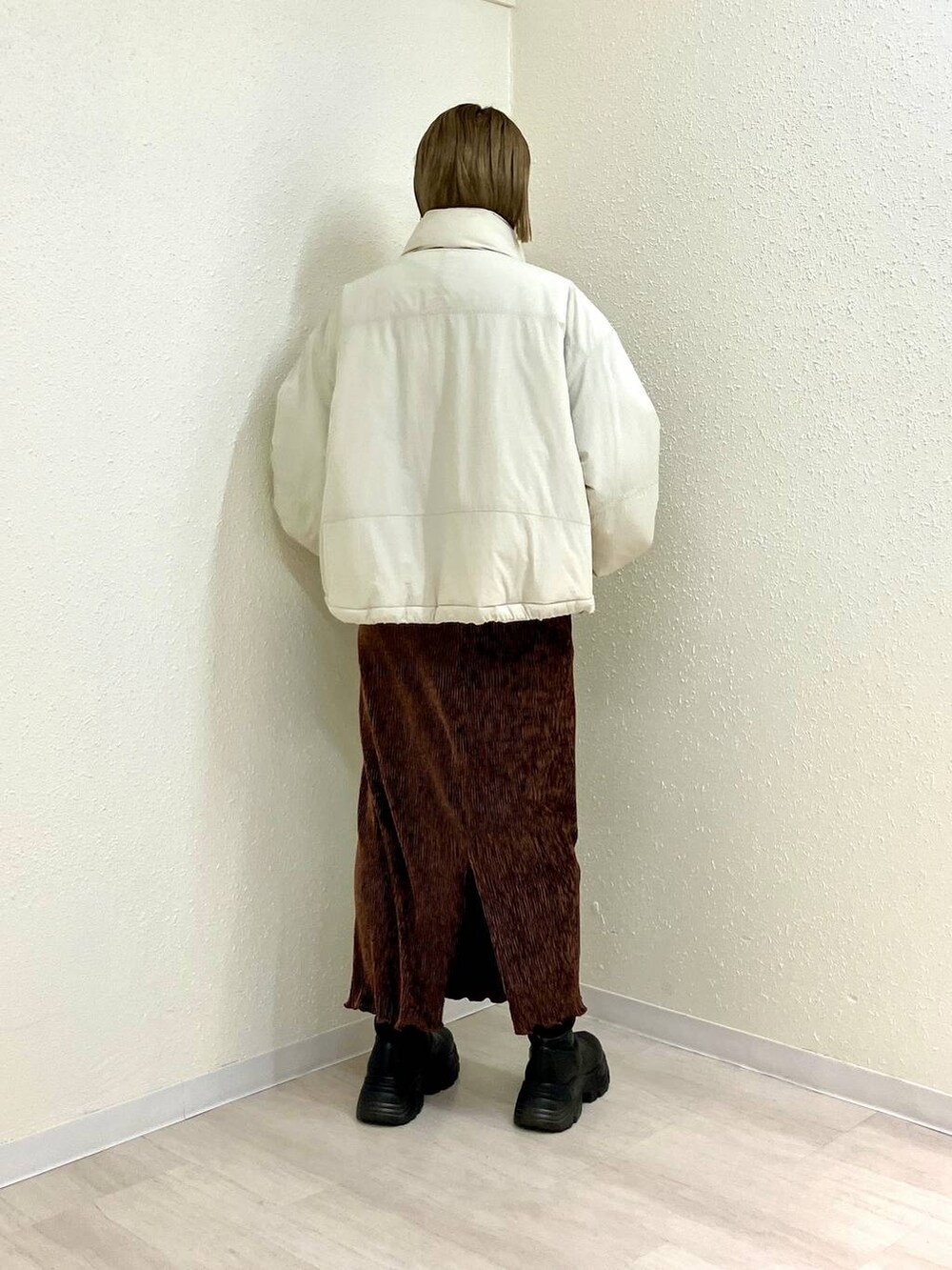 ホワイト系のその他アウター、ブラック系のブーツ、ブラウン系のスカートを着用したレディースの冬コーディネートの3枚目の写真