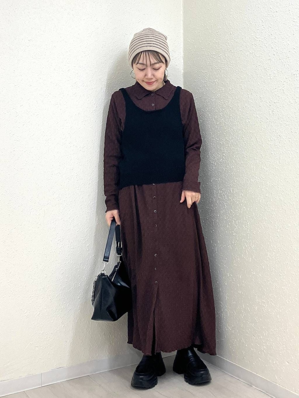 ブラック系のショルダーバッグ、ブラック系のローファー、ブラウン系のワンピースを着用したレディースの冬コーディネートの8枚目の写真