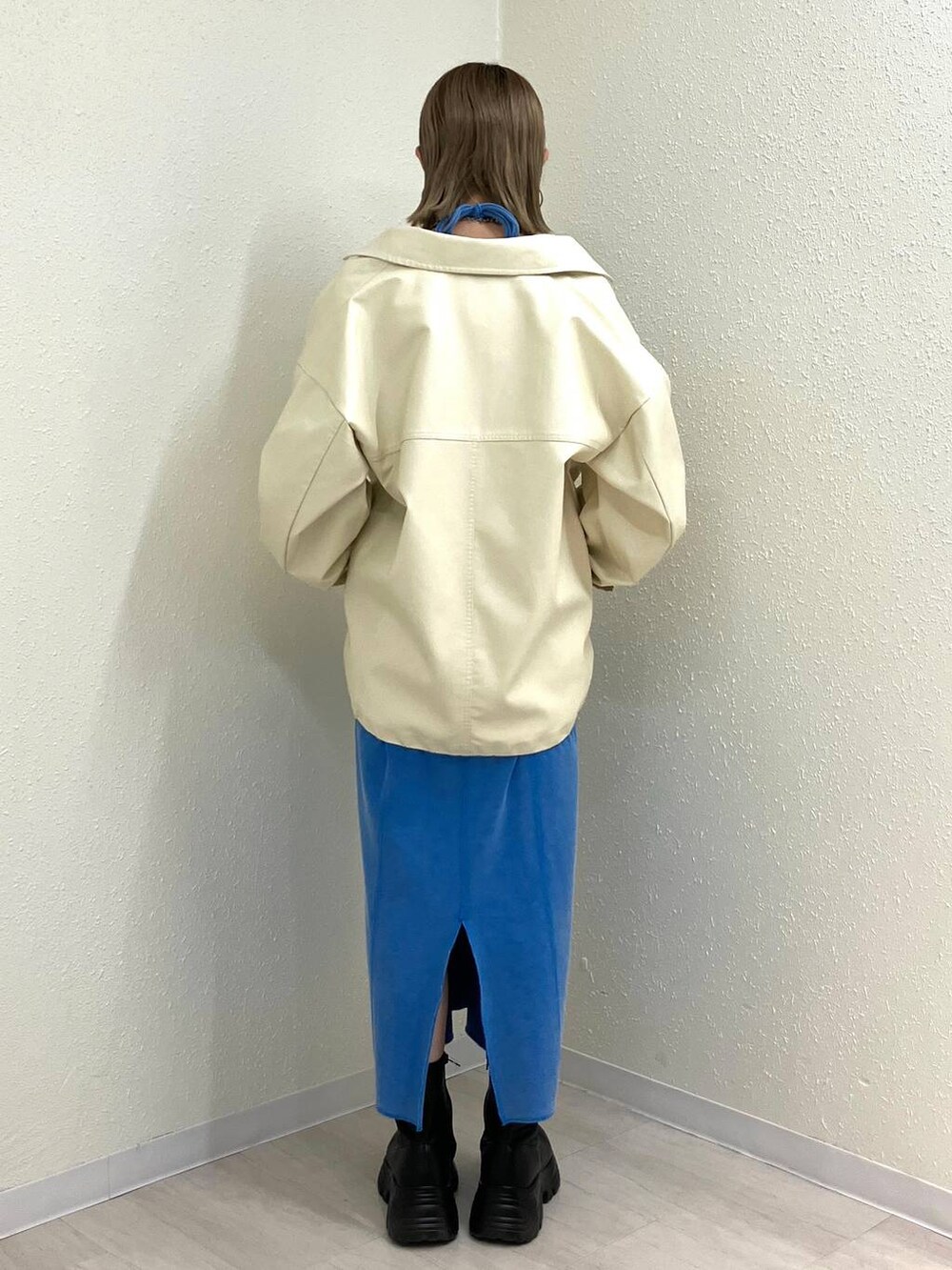 ブラック系のブーツ、ホワイト系のブルゾン、ブルー系のワンピースを着用したレディースの冬コーディネートの4枚目の写真