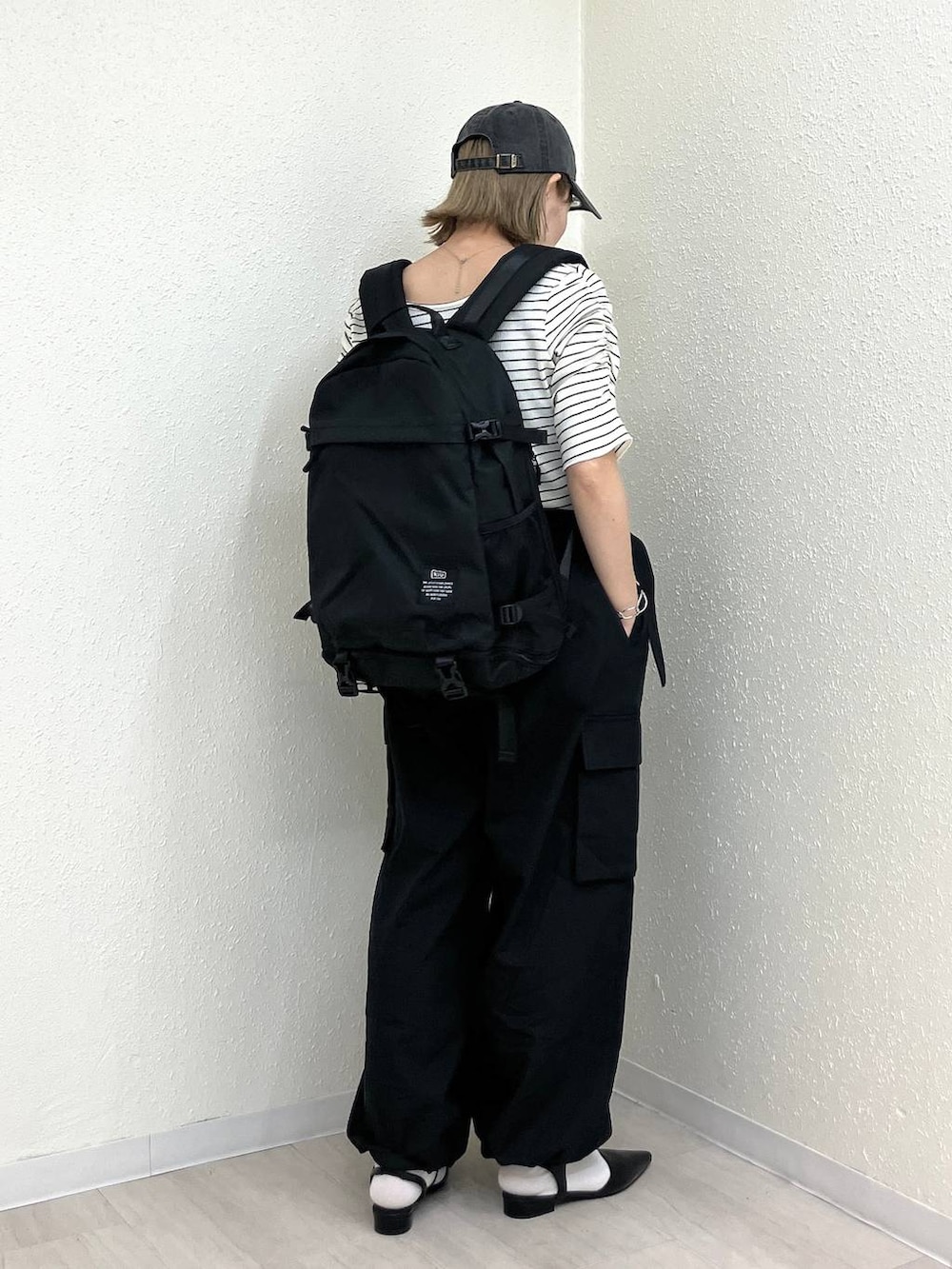 ブラック系のサンダル、ブラック系のカーゴパンツ、ホワイト系のTシャツ/カットソーを着用したレディースの春コーディネートの8枚目の写真