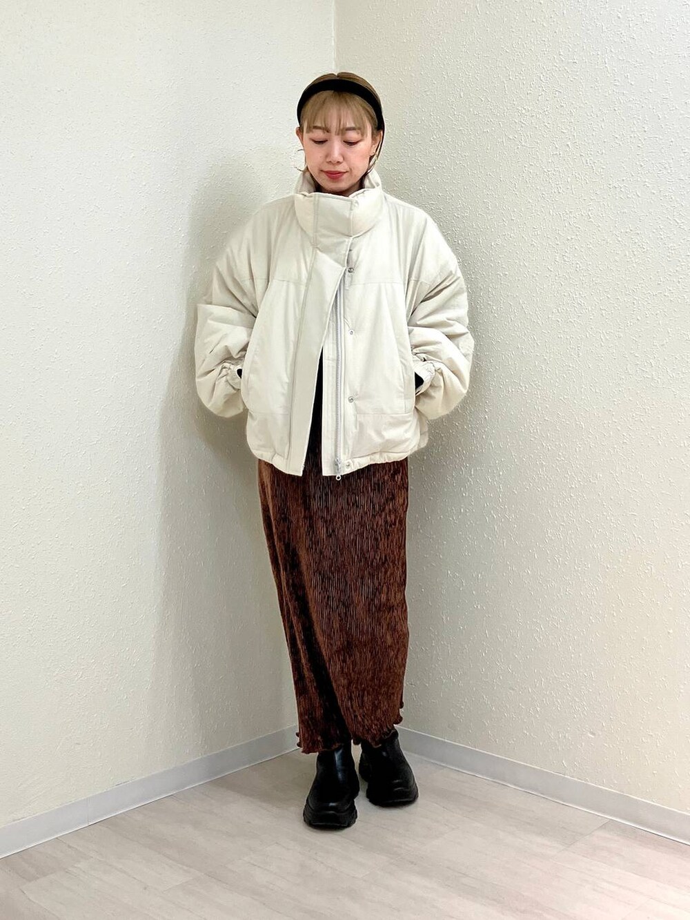 ホワイト系のその他アウター、ブラック系のブーツ、ブラウン系のスカートを着用したレディースの冬コーディネートの4枚目の写真