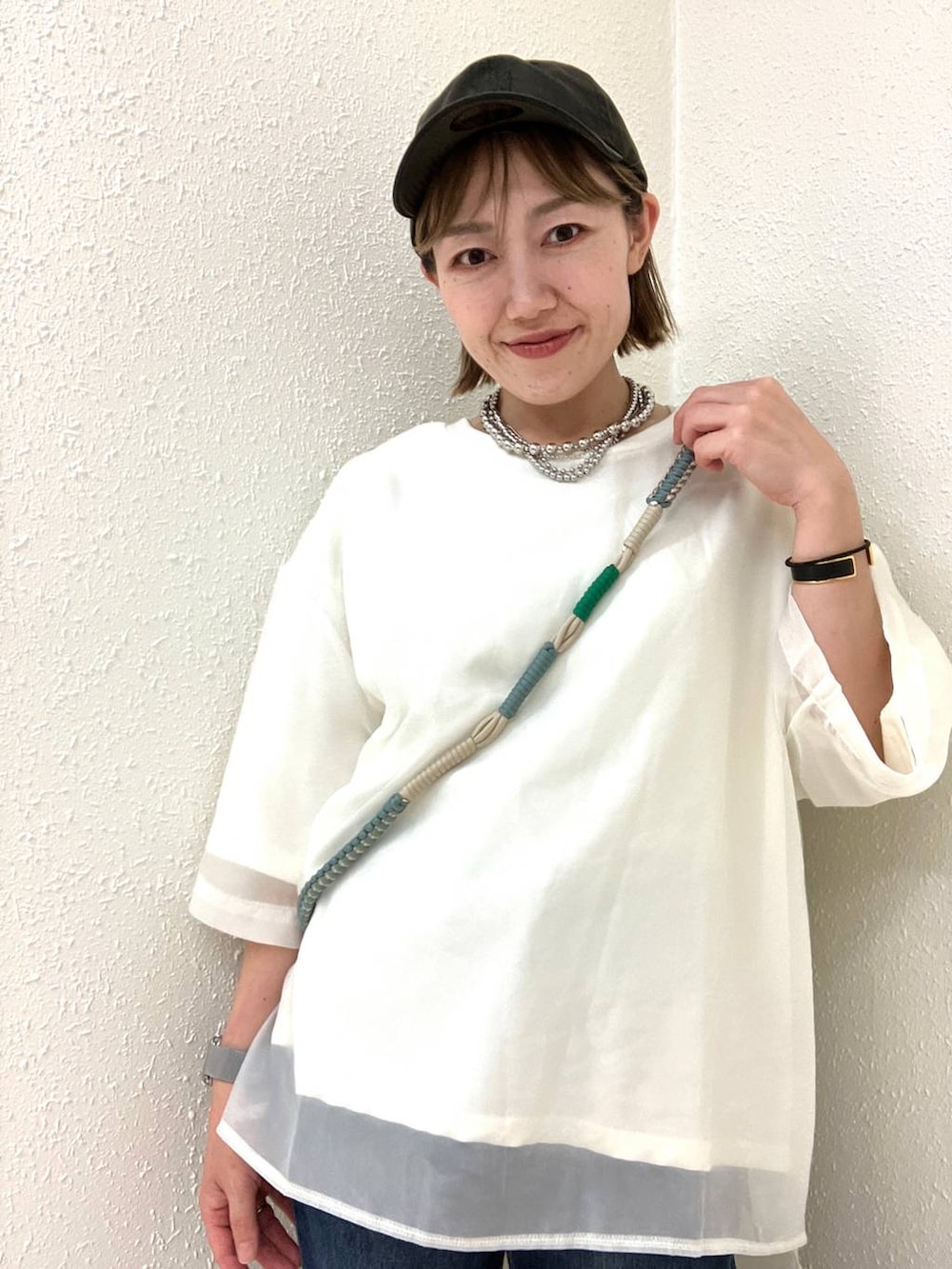 グリーン系のスマホグッズを着用したレディースの秋コーディネートの2枚目の写真