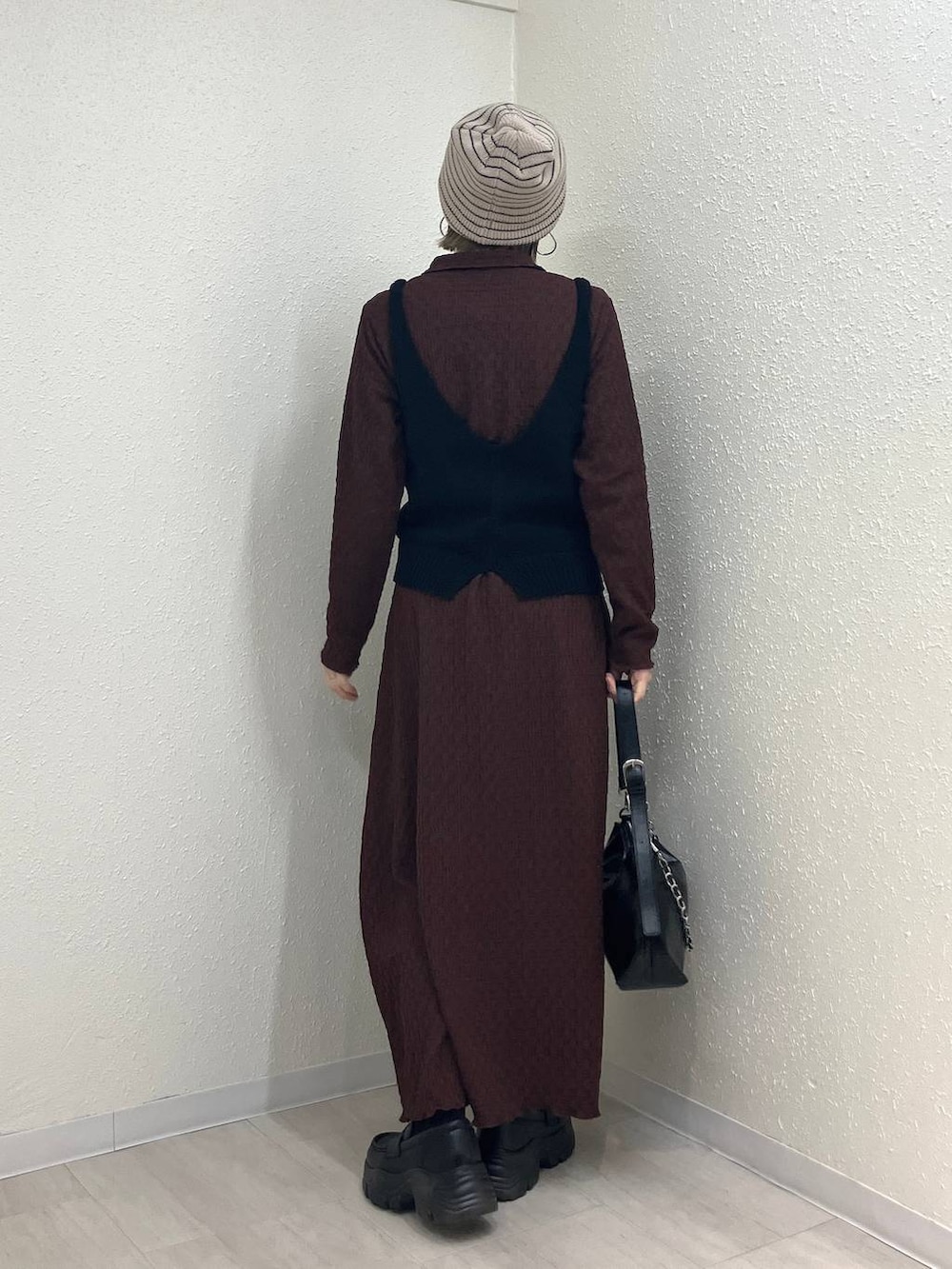 ブラック系のショルダーバッグ、ブラック系のローファー、ブラウン系のワンピースを着用したレディースの冬コーディネートの5枚目の写真