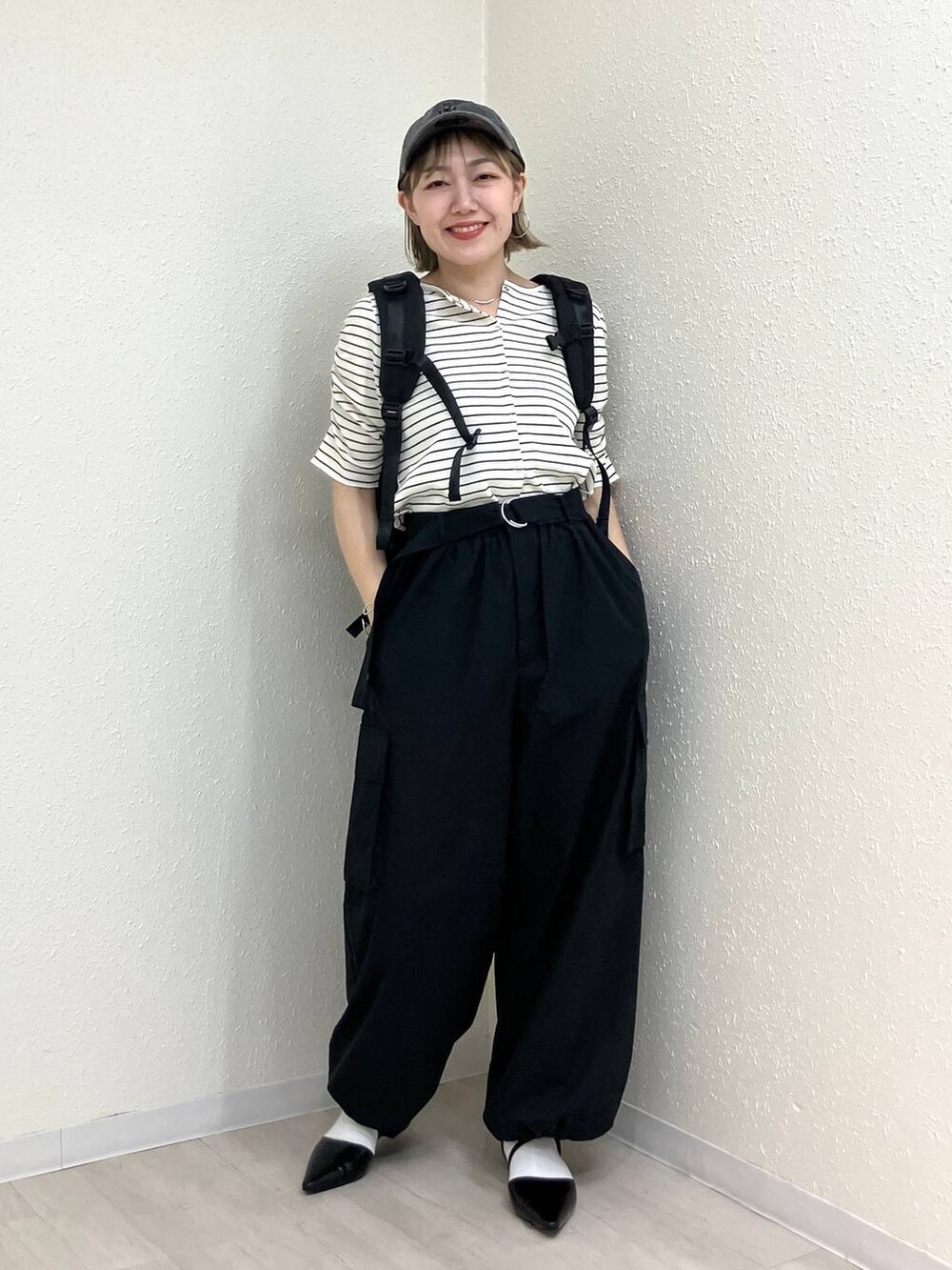 ブラック系のサンダル、ブラック系のカーゴパンツ、ホワイト系のTシャツ/カットソーを着用したレディースの春コーディネートの9枚目の写真