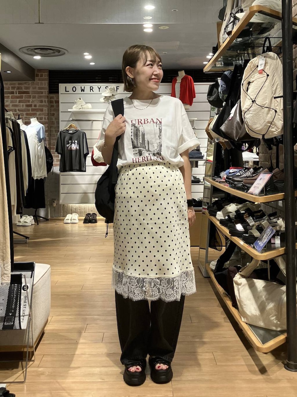ブラック系のデニムパンツ、ブラック系のバックパック/リュック、ホワイト系のスカートを着用したレディースの夏コーディネートの5枚目の写真