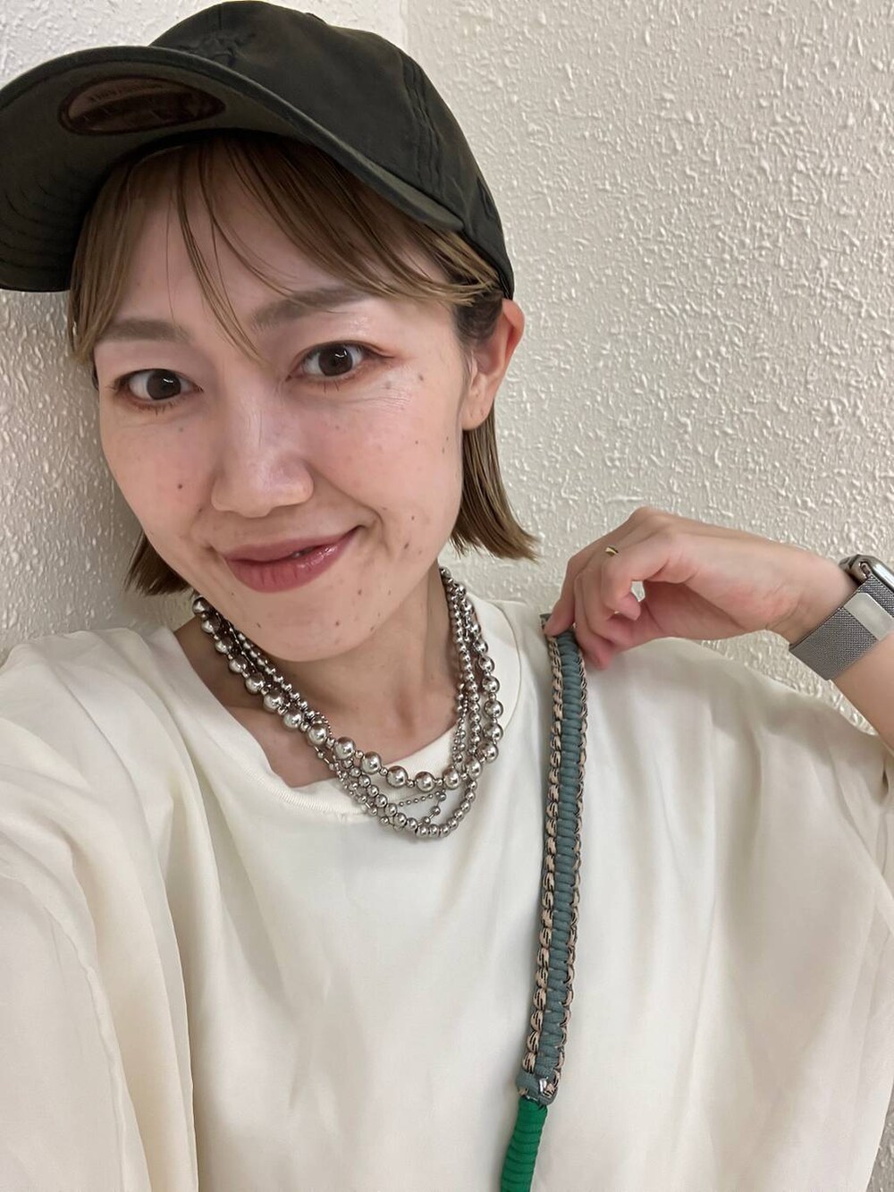 グリーン系のスマホグッズを着用したレディースの秋コーディネートの3枚目の写真