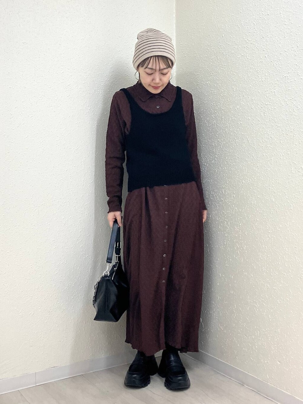 ブラック系のショルダーバッグ、ブラック系のローファー、ブラウン系のワンピースを着用したレディースの冬コーディネートの3枚目の写真