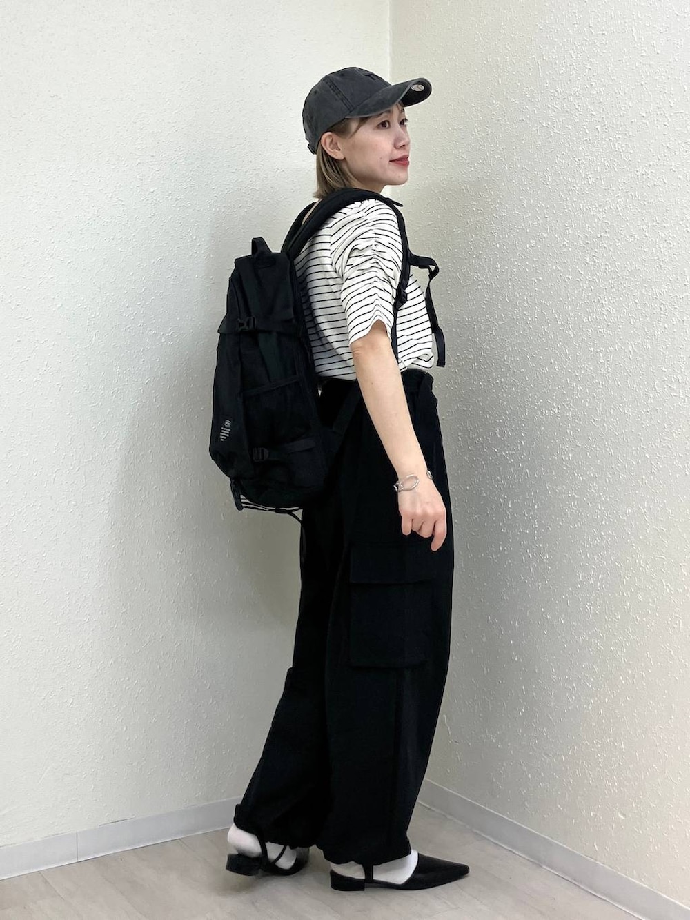 ブラック系のサンダル、ブラック系のカーゴパンツ、ホワイト系のTシャツ/カットソーを着用したレディースの春コーディネートの5枚目の写真