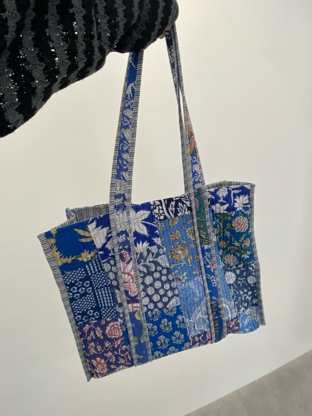 ブルー系のショルダーバッグを着用したレディースの春コーディネートの2枚目の写真