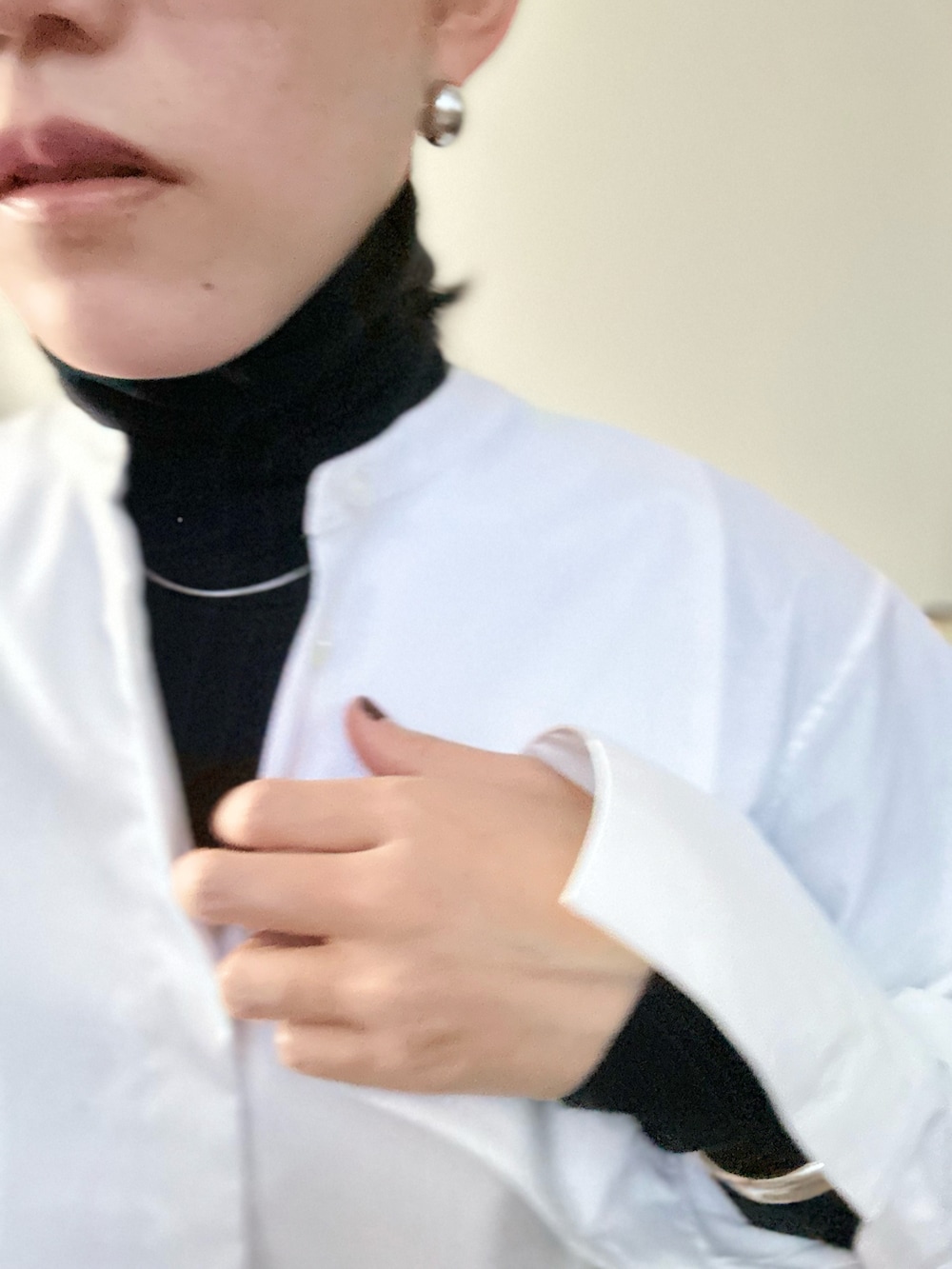 ホワイト系のシャツ/ブラウス、ブラック系のニット/セーター、ブラック系のパンツを着用したレディースの秋コーディネートの2枚目の写真