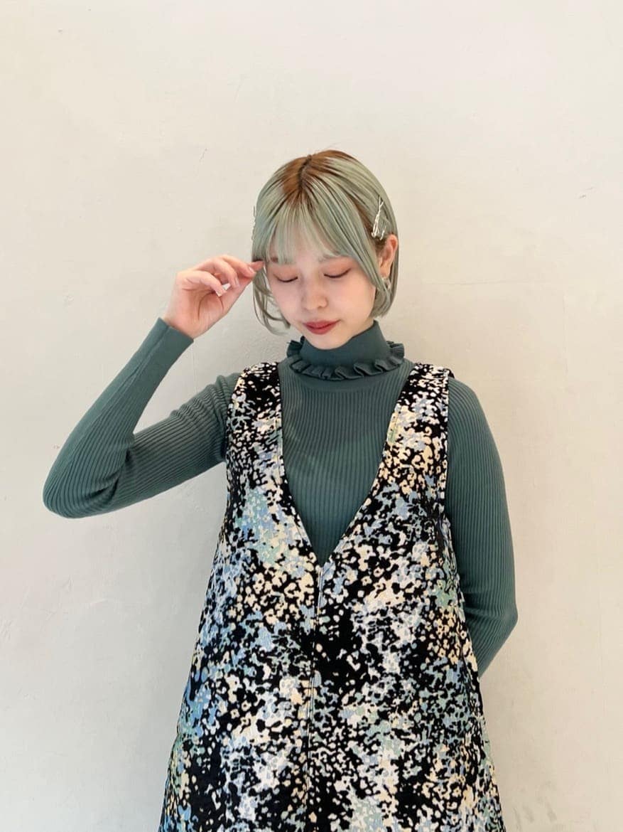 グリーン系のニット/セーター、ブラック系のワンピース、ブラック系のローファーを着用したレディースの秋コーディネートの5枚目の写真