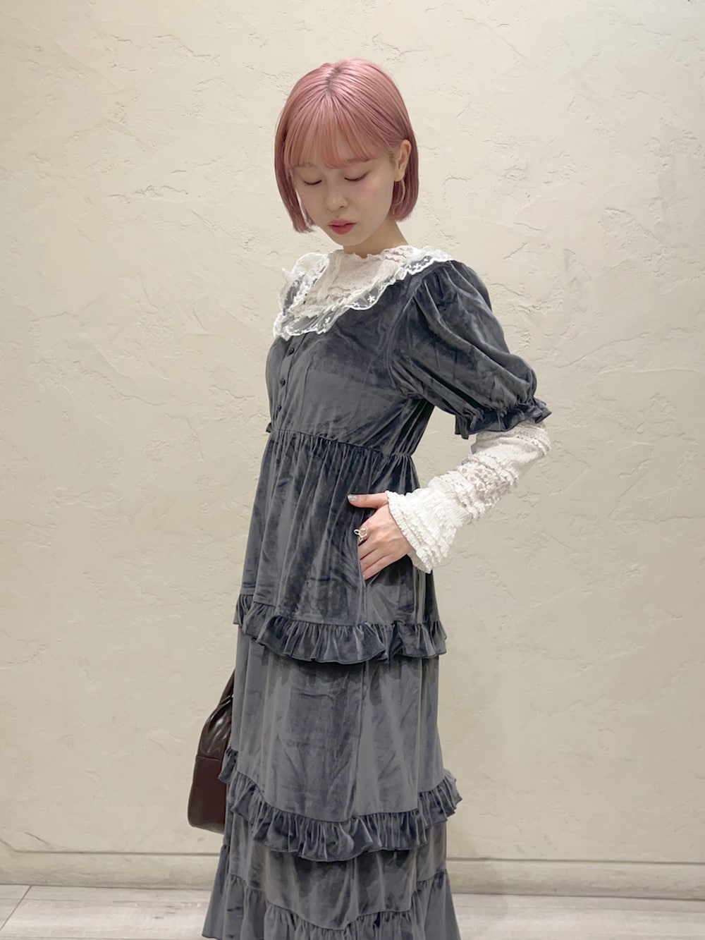 グレー系のワンピース、ブラウン系のハンドバッグ、ホワイト系のスニーカーを着用したレディースの夏コーディネートの6枚目の写真