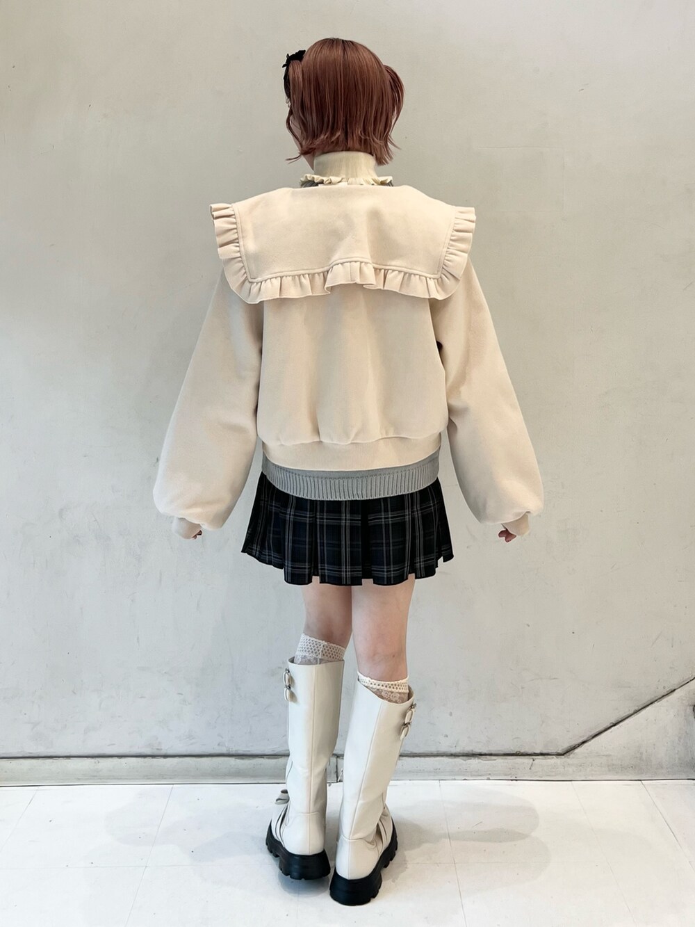 ブラック系のスカート、ブルー系のニット/セーター、ホワイト系のブーツを着用したレディースの冬コーディネートの2枚目の写真