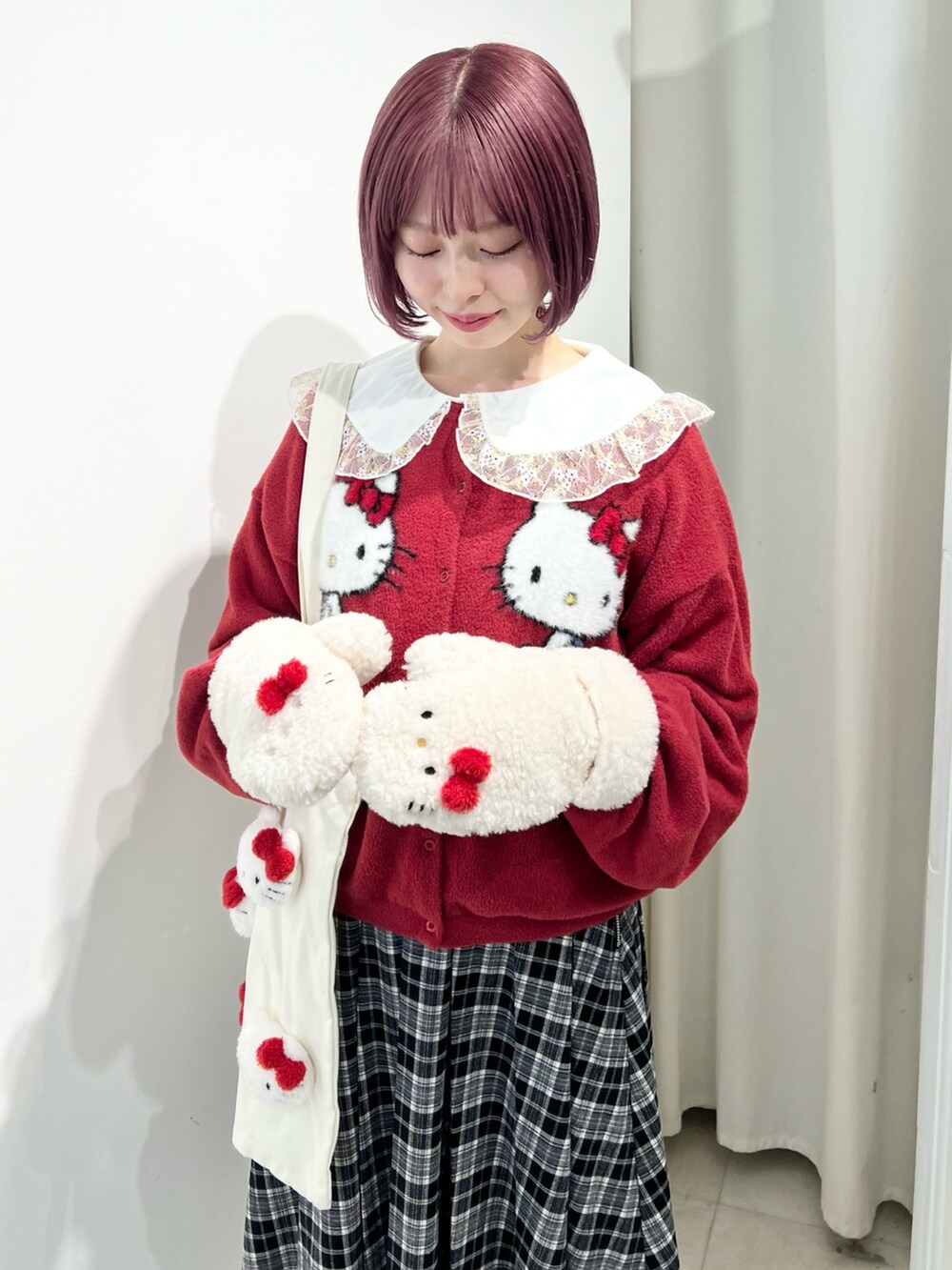 レッド系のカーディガン/ボレロ、ゴールド系のシャツ/ブラウス、ブラック系のスカートを着用したレディースの秋コーディネートの7枚目の写真