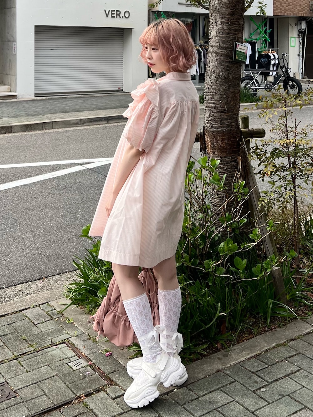 ピンク系のワンピース、ピンク系のトートバッグ、ホワイト系のスニーカーを着用したレディースの春コーディネートの6枚目の写真