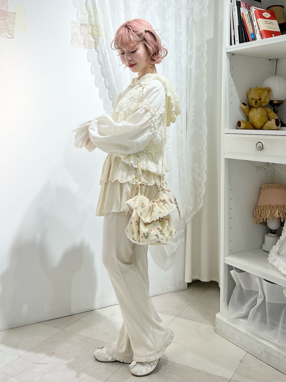 ホワイト系のスニーカー、ホワイト系のスウェットパンツ、ホワイト系のショルダーバッグを着用したレディースの冬コーディネートの4枚目の写真