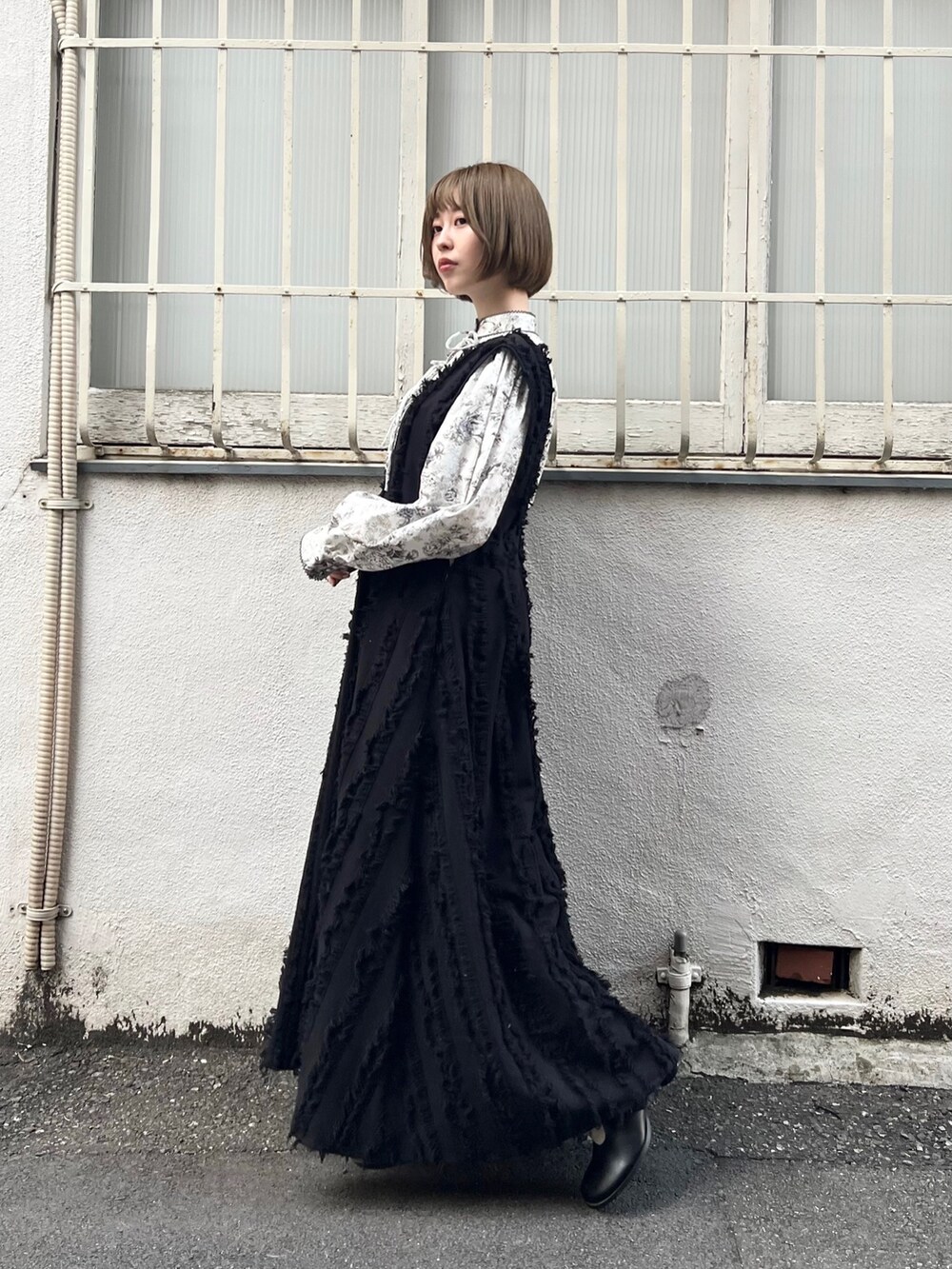 グレー系のシャツ/ブラウス、ブラック系のワンピース、ブラック系のブーツを着用したレディースの秋コーディネートの3枚目の写真