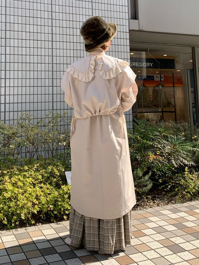 ベージュ系のスカート、ホワイト系のトレンチコート、ホワイト系のパンプスを着用したレディースの冬コーディネートの4枚目の写真