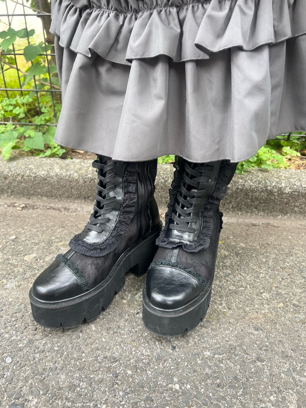 グレー系のワンピース、ブラウン系のハンドバッグ、ブラック系のブーツを着用したレディースの夏コーディネートの10枚目の写真