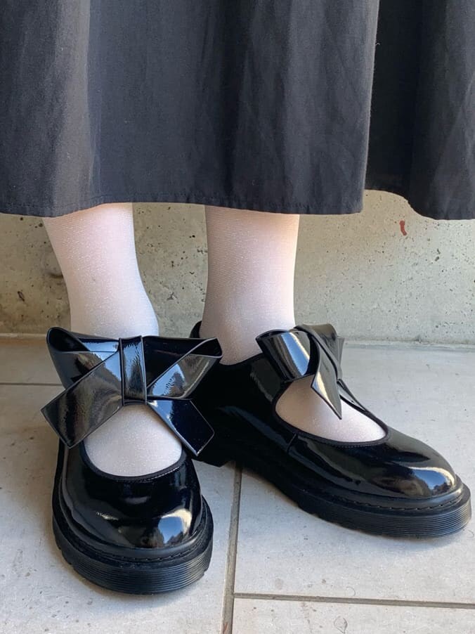 ブラック系のパンプス、ブラック系のワンピース、ブラック系のショルダーバッグを着用したレディースの冬コーディネートの8枚目の写真
