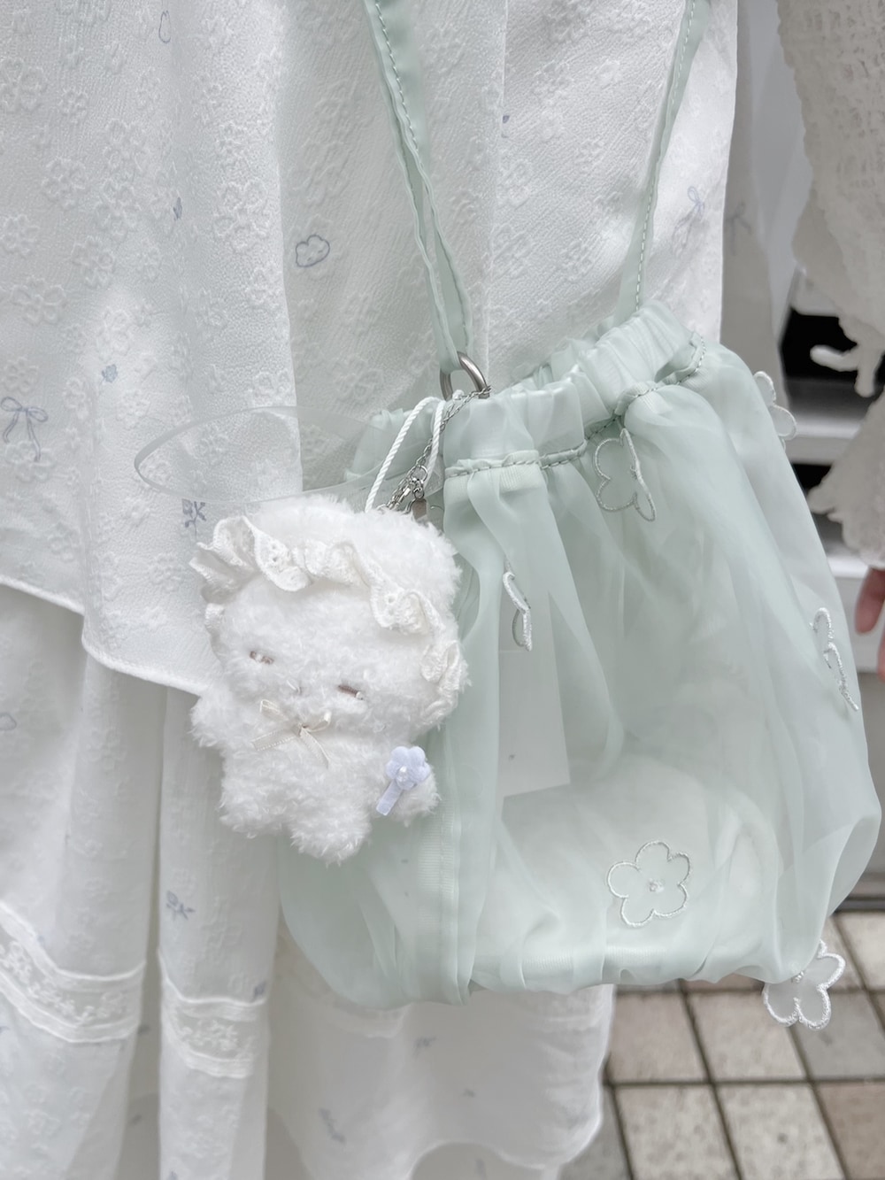 ホワイト系のTシャツ/カットソー、グリーン系のハンドバッグ、ホワイト系のワンピースを着用したレディースの冬コーディネートの9枚目の写真