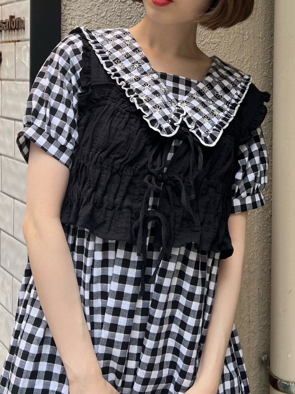 ブラック系のベスト、ブラック系のサンダル、ブラック系のワンピースを着用したレディースの夏コーディネートの8枚目の写真