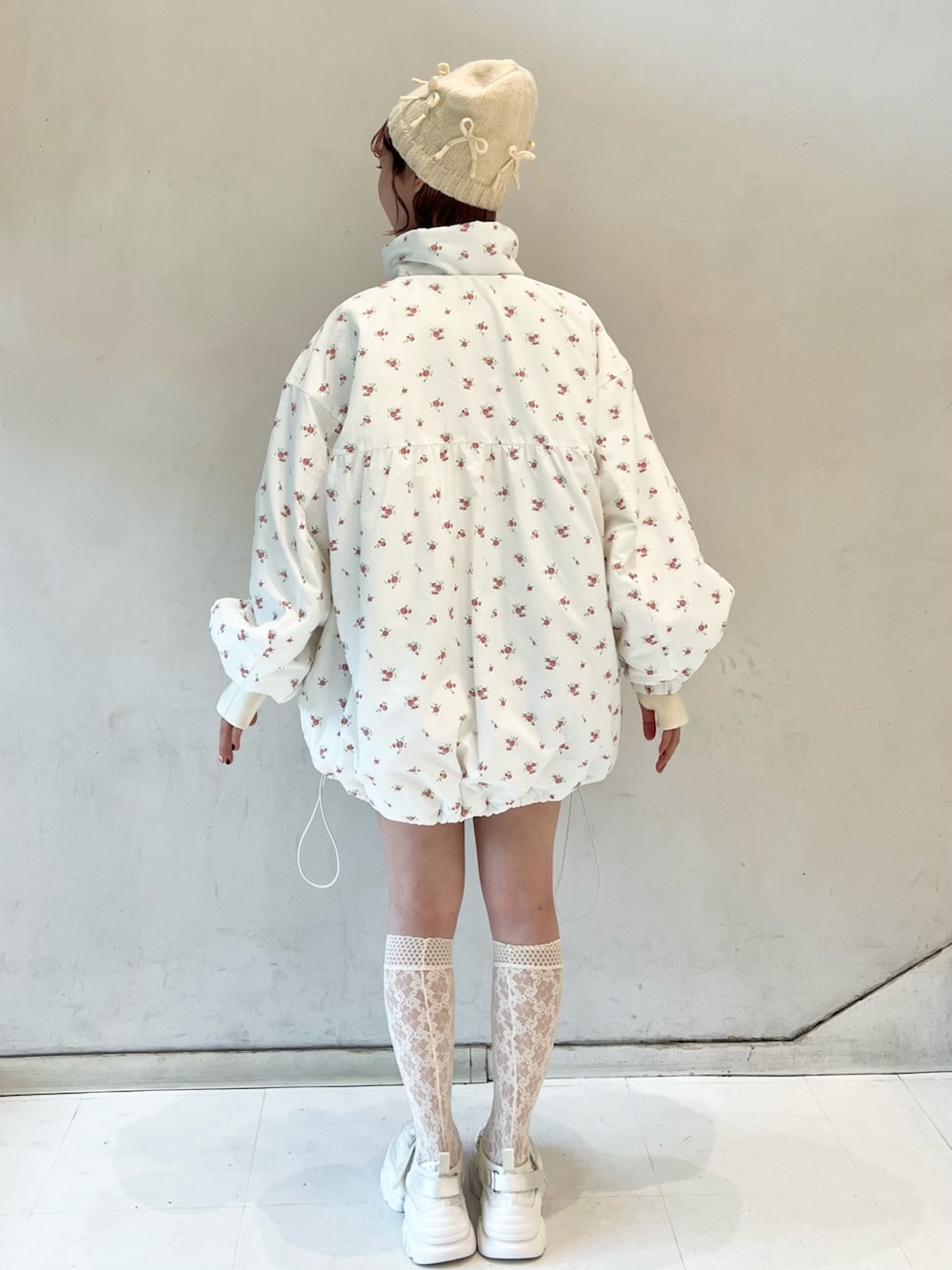 ピンク系のブルゾン、ベージュ系のスウェットパンツ、ホワイト系のニット/セーターを着用したレディースの冬コーディネートの5枚目の写真