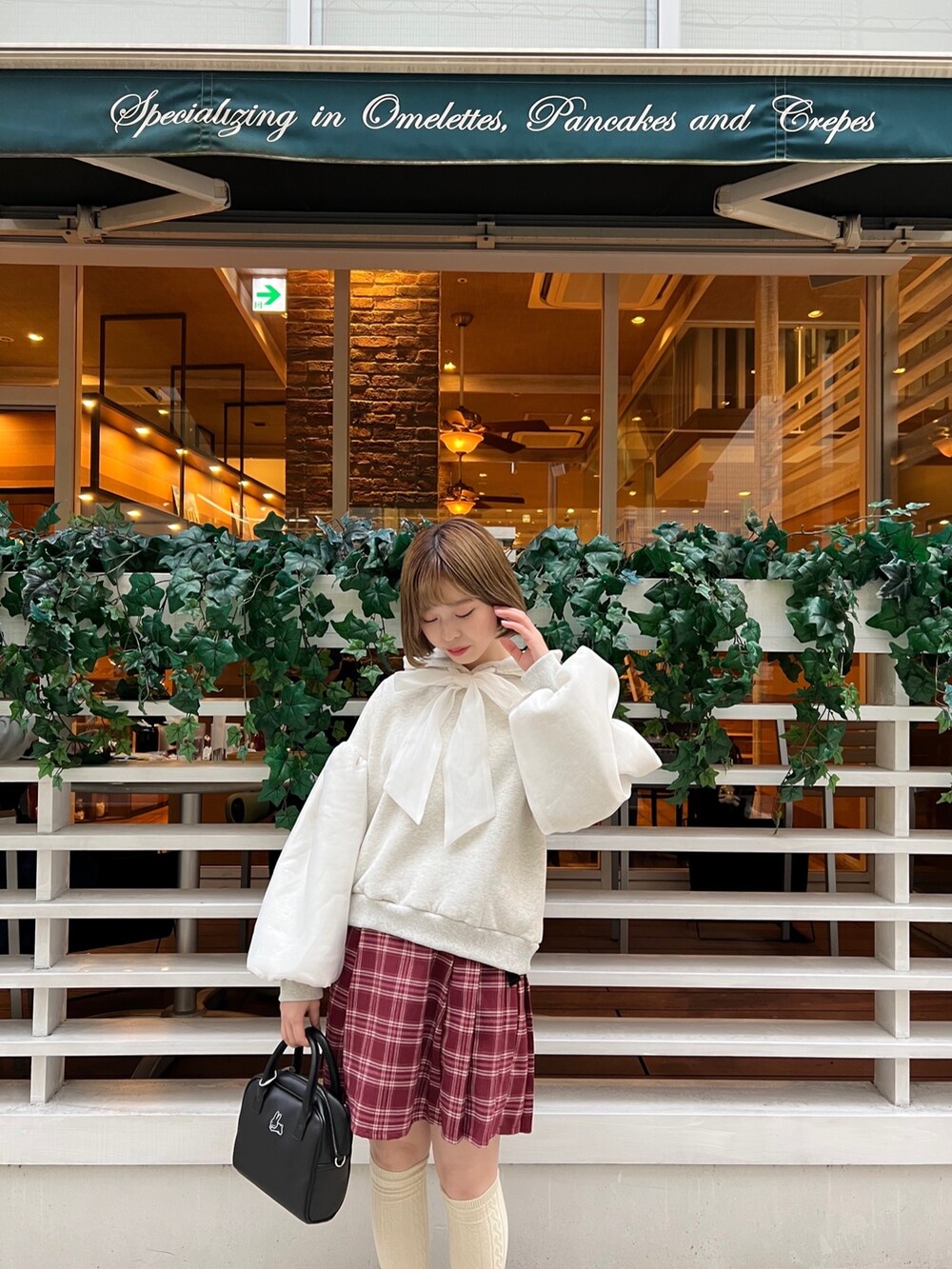 ブラック系のローファー、ホワイト系のパーカー、ブラック系のボストンバッグを着用したレディースの冬コーディネートの7枚目の写真