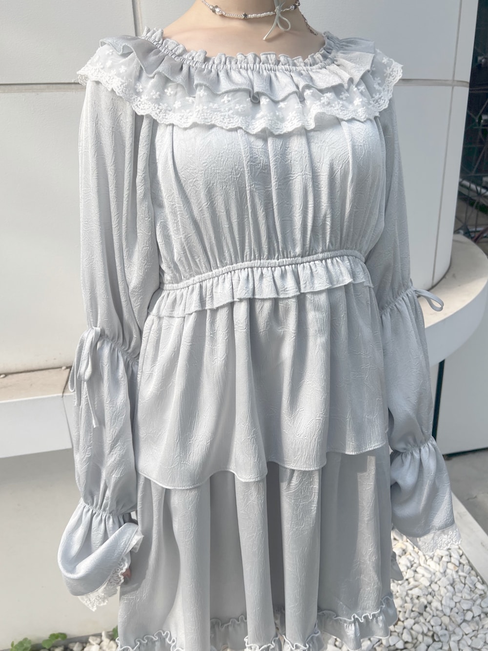 ブルー系のワンピース、ブルー系のトートバッグ、ホワイト系のブーツを着用したレディースの夏コーディネートの7枚目の写真