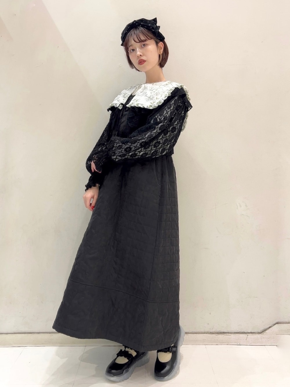 ブラック系のワンピース、ブラック系のカーディガン/ボレロ、ブラック系のスニーカーを着用したレディースの冬コーディネートの3枚目の写真